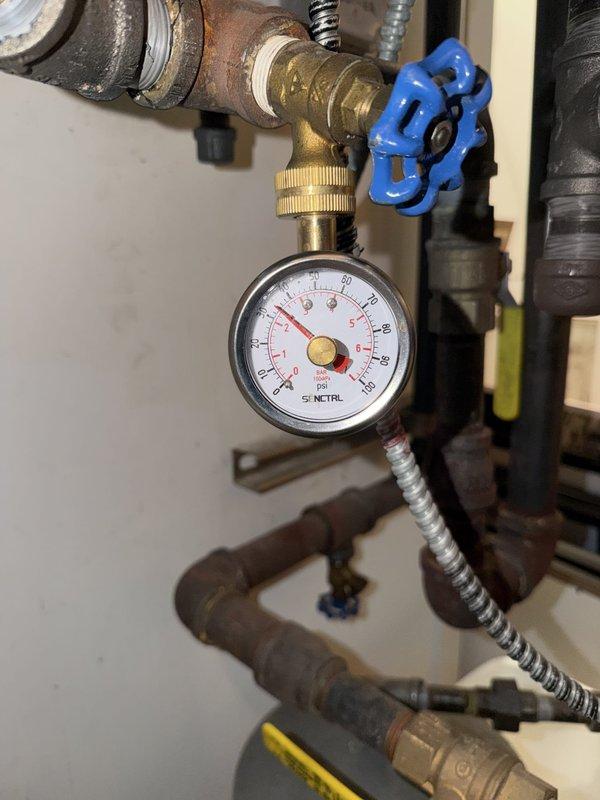 Responded to service call for non-operational radiant heating system. Upon inspection, found low system pressure as indicated by the boiler pressure gauge reading below operational threshold. Verified thermostat programming showing active heating schedule set for 77°F at 6:30 AM wake period. Inspected boiler feed water assembly including pressure gauge, isolation valves, and braided supply line connections. Restored proper system pressure through the fill valve to bring boiler pressure into normal operating range. Verified all isolation valves in correct positions and confirmed no visible leaks at connections. System tested and confirmed radiant heat restored to normal operation with proper pressure maintained.