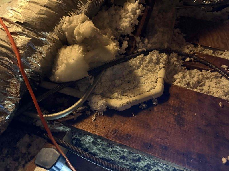 Responded to service call for slow-draining furnace condensate line in attic space. Accessed attic via pull-down ladder, located HVAC system and identified clogged condensate drain line. Cleared blockage by blowing out drain line to restore proper drainage flow and prevent potential water damage or system shutdown.