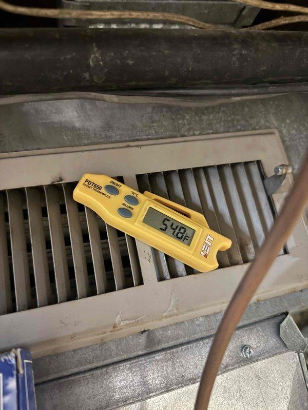 # HVAC Service Call - No Cooling Issue

Responded to service call for dual air conditioning system with one unit failing to produce adequate cooling. Customer reported unit only delivering cool air rather than cold air. Both systems are 15-20 years old.

## Diagnostic Findings

Performed comprehensive system evaluation on the affected unit. Utilized digital temperature measurement equipment to assess air temperature differential across the evaporator coil, recording supply air temperature of 54.8°F. Inspected indoor air handler and plenum assembly for proper airflow and component operation.

Conducted visual inspection of air filtration system, noting moderate dust accumulation on pleated filter media. Filter appeared to be restricting airflow, which can reduce system efficiency and cooling capacity. Examined metal ductwork and housing components, observing significant aging with dust and grime buildup throughout the system.

Assessed furnace/air handler unit configuration, including P