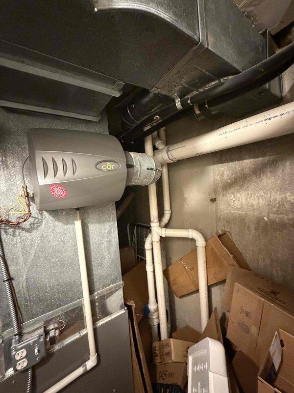 Evaluated 29-year-old R22 air conditioning system serving home addition and found multiple failed components beyond economical repair. System utilizes phased-out R22 refrigerant, making future service increasingly difficult and costly. Documented existing indoor humidifier installation integrated with ductwork in mechanical room and outdoor condensing unit positioned alongside building foundation. Provided comprehensive replacement recommendations for complete system upgrade to modern, efficient equipment compatible with current refrigerant standards.