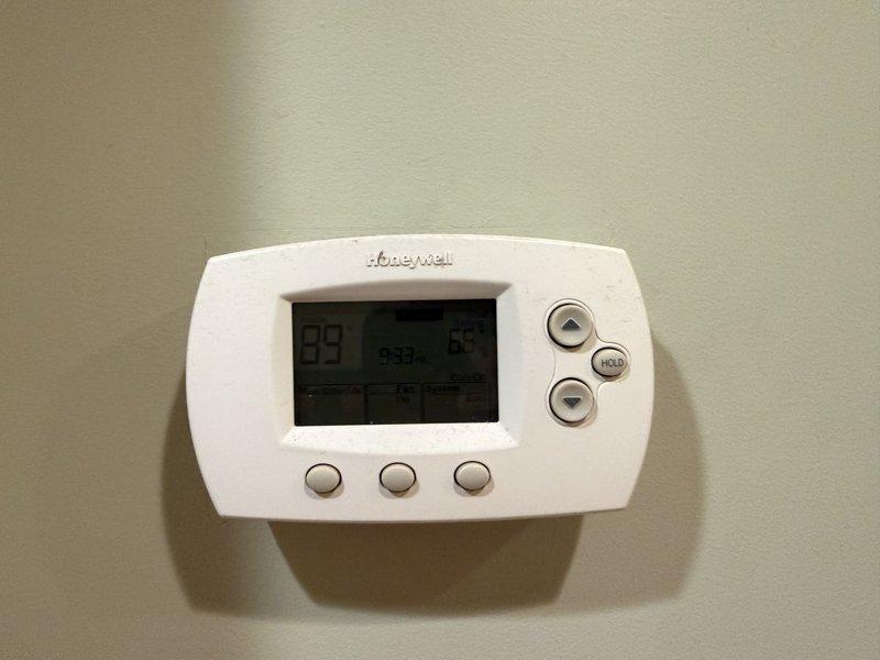 Responded to no cooling complaint on second floor for 10-year-old air conditioning system. Upon arrival, found thermostat displaying 99°F ambient temperature with setpoint at 64°F, indicating system was not achieving desired cooling. Performed diagnostic testing including supply air temperature measurement at register, which recorded 88.5°F—well above acceptable cooling range and confirming inadequate system performance. Noted visible dust accumulation on supply register, suggesting potential airflow restrictions. Accessed outdoor condensing unit without requiring ladder assistance and conducted comprehensive system evaluation to identify root cause of cooling failure.
