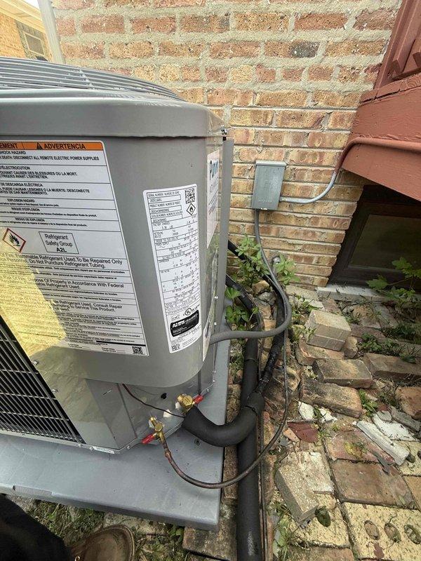 Completed full replacement of two residential HVAC systems, including one unit installed in the attic and one outdoor condenser unit positioned on a concrete pad against the building exterior. The outdoor unit was properly mounted with refrigerant lines and electrical conduit routed along the brick wall, with disconnect box installed for code compliance. New Honeywell Home digital thermostat was installed and programmed to control the system. All equipment was tested for proper operation, refrigerant charge verified, and electrical connections confirmed secure. Job site was left clean and all debris removed.
