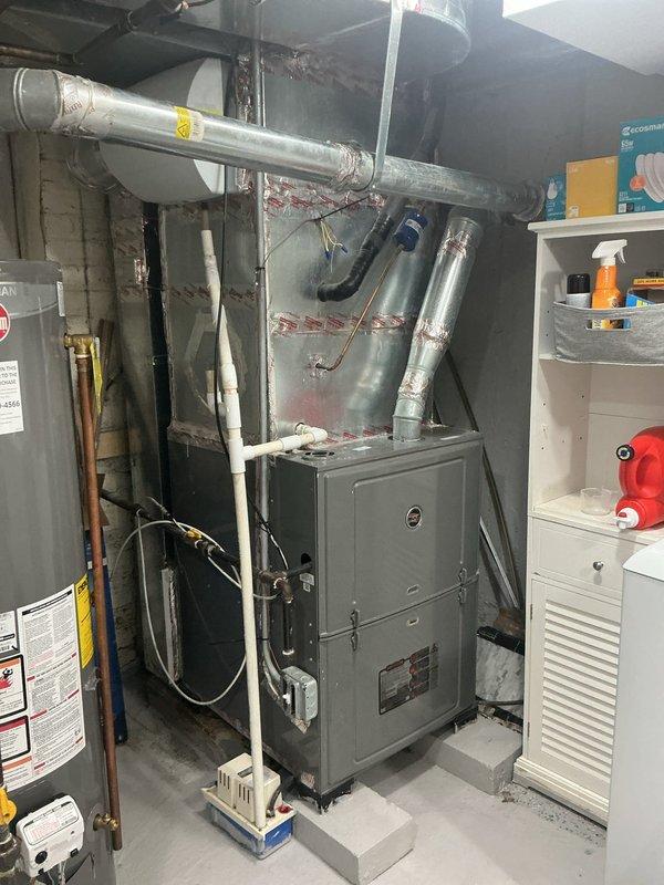 Responded to no cooling complaint on 9-year-old air conditioning system. Upon inspection, found unit was oversized for the home and had a freeze protection sensor previously installed by another technician that was cycling the compressor off while keeping the blower running continuously. This configuration prevented proper cooling, resulting in first floor temperatures exceeding 80 degrees while basement remained in upper 60s, indicating poor air distribution and inadequate dehumidification. Examined evaporator coil area and drain pan, noting evidence of previous moisture accumulation and mineral deposits consistent with freeze-up history. Documented existing equipment configuration and sensor installation. Discussed system sizing concerns and recommended solutions including potential replacement with properly sized equipment, improved airflow management, and thermostat adjustments to address short-cycling and freeze-up issues inherent to oversized systems.