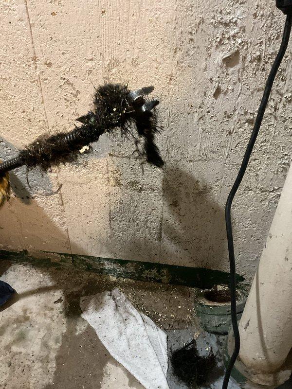 Performed camera inspection of main sewer line and rodding service as a follow-up visit. Successfully cleared the line and confirmed proper drainage flow with video documentation showing the condition of the pipe interior and cleanout access point in basement utility area.