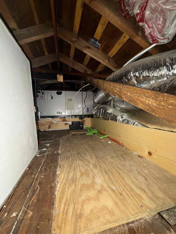 Provided comprehensive estimate for complete air conditioning system replacement of twenty-year-old unit. Evaluated existing outdoor condenser unit showing significant age-related wear and assessed attic-mounted air handler with associated ductwork system. Documented current system configuration including exterior condenser placement on concrete pad adjacent to building structure and interior HVAC components installed in attic space with flexible metallic ductwork distribution network.