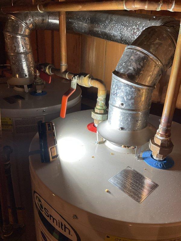 Removed and replaced one 50-gallon water heater from a twinned set installation in basement utility area. Re-piped the plumbing system to accommodate a single water heater configuration, eliminating the dual setup. Reconnected the recirculation line to the new water heater to maintain hot water circulation throughout the system. Capped off the unused exhaust vent and gas line from the removed unit to ensure safe disconnection. Installed new AO Smith 50-gallon residential water heater with proper hot and cold water connections using copper piping. Connected expansion tank above the unit and installed shut-off valves with color-coded handles for easy identification. Verified all pipe connections for proper seal and tested system operation. Cleared obstructions to working area and ensured code-compliant installation.