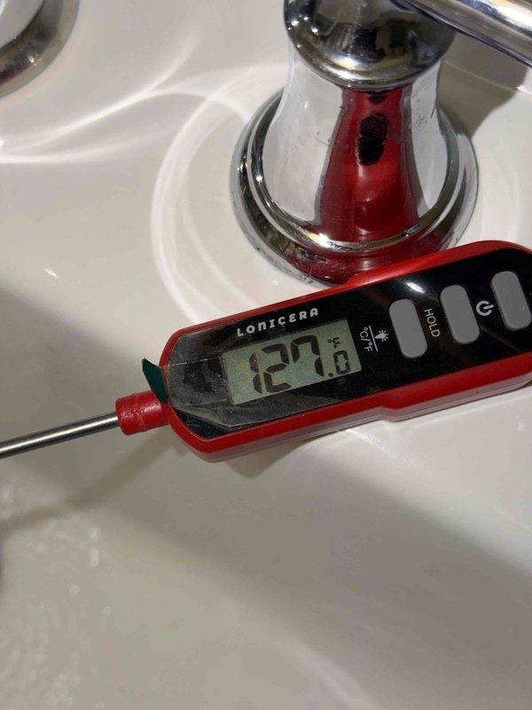 Responded to callback regarding excessively hot water temperature following previous day's water heater installation. Upon arrival, verified outlet temperature at fixture measured 127.8°F using calibrated digital thermometer. Inspected Bradford White 50-gallon natural gas water heater and reviewed manufacturer specifications indicating danger threshold of 125°F for scalding prevention. Adjusted temperature setting on gas control valve to reduce outlet temperature to safe operating range per industry standards and manufacturer recommendations for residential applications.
