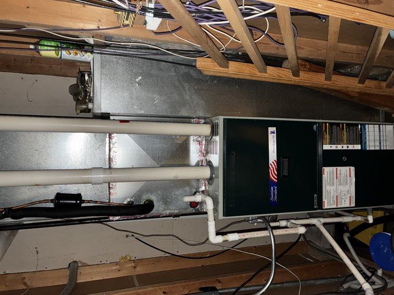Conducted comprehensive evaluation of existing HVAC system and water heating equipment to provide full system replacement estimate. Customer requested quote for conversion from conventional tank-style water heater to tankless unit. Inspected attic-mounted air handler system, ductwork configuration, condensate drainage system, and thermostat controls to assess current installation and determine compatibility requirements for proposed tankless water heater integration. Documented existing equipment specifications, spatial constraints, and utility connections. Photographed current HVAC air handler with associated ductwork and PVC condensate lines, as well as White-Rodgers digital thermostat for reference. Prepared detailed estimate for tankless water heater installation including necessary modifications to gas lines, venting, electrical connections, and water supply piping to accommodate transition from tank to on-demand water heating system.