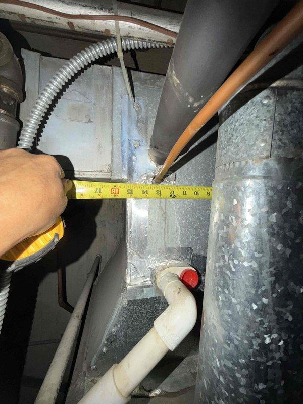 Responded to no cooling complaint on rooftop unit accessed via 15-foot telescopic ladder. Upon inspection, found unit blowing hot air with visible signs of aging electrical components including corroded wire terminals and discolored connections at the contactor assembly. Observed accumulated dirt and debris in electrical compartment along with weathered capacitor and wiring showing service wear. Measured clearances between mechanical components and ductwork to assess system configuration and accessibility for repairs.