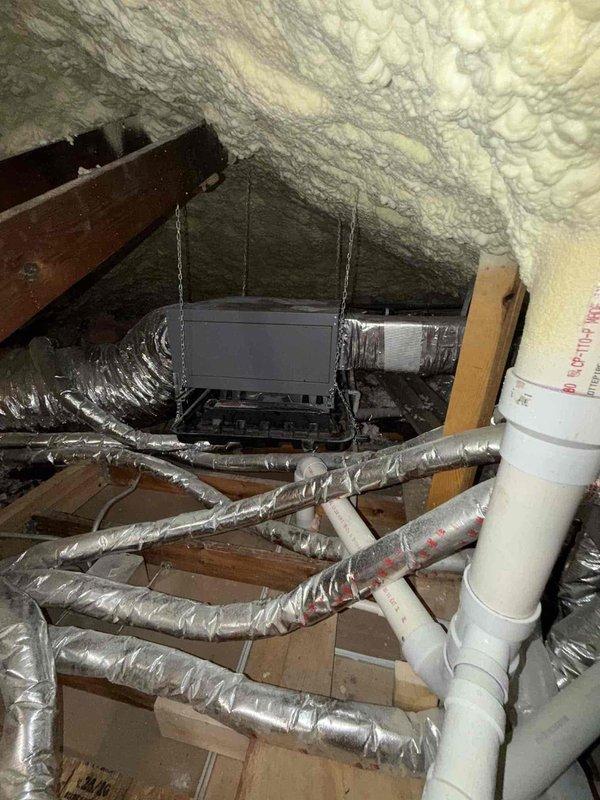 Completed estimate for full HVAC system replacement in attic installation. Existing air handler and condensing unit over 10 years old experiencing intermittent cycling issues and accessibility challenges for ongoing service. Attic access assessed using customer-provided ladder. Documented existing conditions including spray foam insulation throughout attic space, current ductwork configuration with reflective foil wrapping, and suspended air handler with chain mounting system. Photographed extensive frost/ice accumulation on roof decking indicating potential ventilation or insulation concerns that should be addressed during replacement. Noted existing PVC drainage line routing and current duct runs for replacement planning. System replacement recommended due to age, reliability issues, and service accessibility limitations.