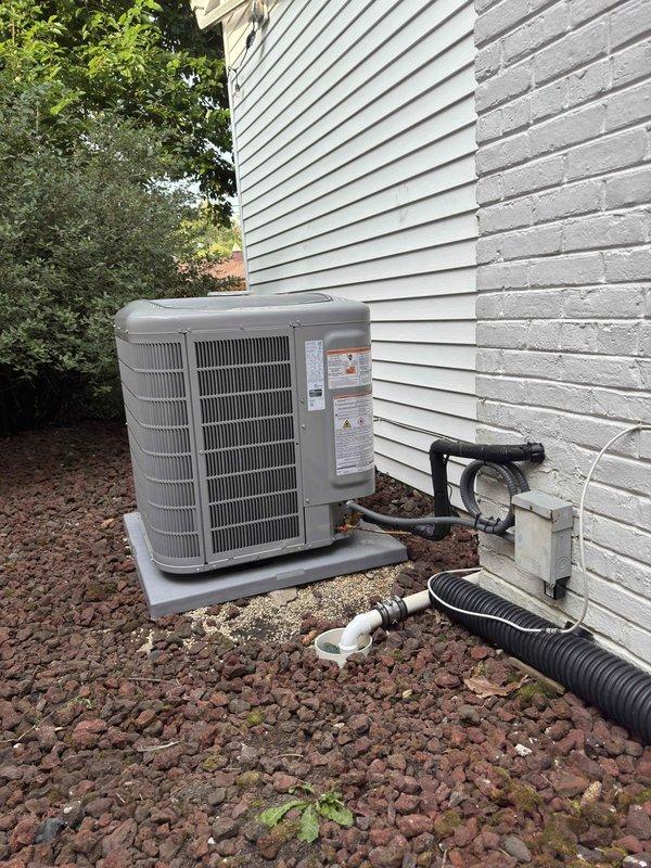 Completed full HVAC system replacement including furnace, air conditioning condenser, evaporator coil, humidifier, and thermostat. Installed new outdoor condensing unit on existing concrete pad with proper refrigerant line connections and drainage. Interior air handler installed in basement utility area with new ductwork connections, copper refrigerant lines, and system accessories. All components properly mounted, connected, and tested for operational performance. System commissioned and verified for proper heating and cooling functionality.