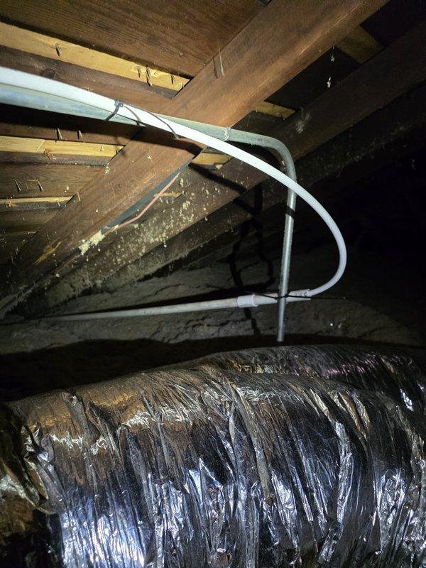 Returned to property to investigate reported water leak in HVAC system. Upon inspection of attic space, located flexible supply duct with intact insulation wrapping and adjacent PVC condensate drain line. Examined surrounding areas and discovered deteriorated paper-backed insulation material on attic floor showing significant moisture damage, discoloration, and breakdown. Material exhibited yellowing, flaking, and crumbling consistent with previous water exposure. Documented conditions with photographs showing affected insulation and HVAC ductwork configuration. No active water leak detected at time of inspection from condensate drain line or ductwork connections. Recommended monitoring system for future leaks and advised replacement of damaged attic insulation to restore proper thermal efficiency.
