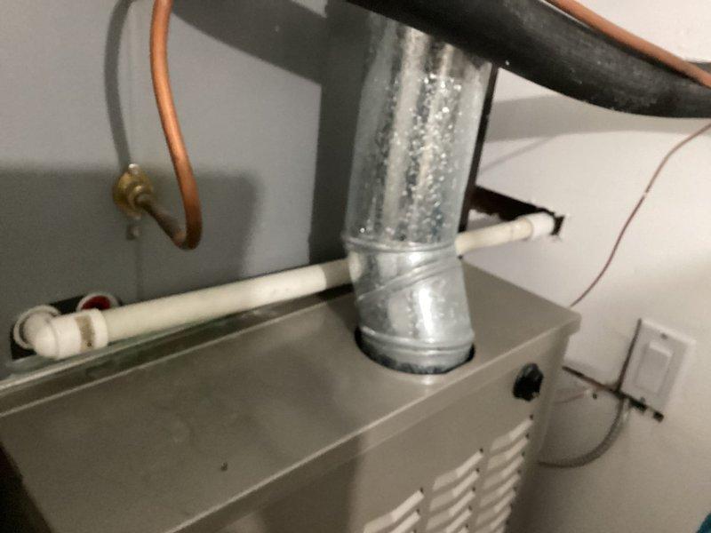 Completed routine HVAC maintenance agreement service on residential cooling system. Inspected air handler unit in attic space, noting active condensation on supply ductwork indicating proper system operation and temperature differential. Observed copper refrigerant lines, PVC condensate drainage, and electrical connections all in functional condition. Replaced 16x25x1 air filter as part of scheduled maintenance protocol. Verified condensate drainage system functionality at utility sink location, confirming proper discharge of moisture removed during cooling cycle. All system components operating within normal parameters at time of service.