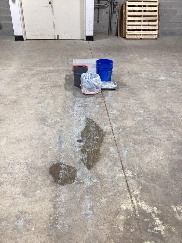 Responded to no cooling call on rooftop unit. Upon arrival, accessed facility using provided lockbox and located RTU above commercial space. Identified active refrigerant leak requiring immediate attention. Placed multiple collection containers on floor beneath unit to capture leaking refrigerant and prevent environmental contamination. Documented leak location and severity with photographs showing RTU mounted to ceiling structure with visible piping infrastructure. Unit requires refrigerant recovery, leak repair, and system recharge to restore cooling operation.
