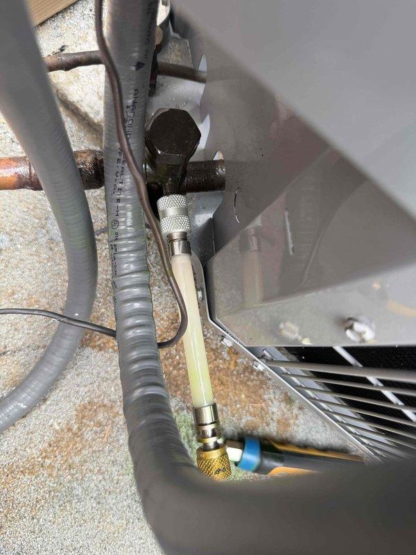 Returned to system to add R-410A refrigerant with sealant, charging up to 3 pounds to address refrigerant loss. Connected manifold gauges to service ports on weathered copper refrigerant lines and performed leak detection procedures. Added leak sealant to system followed by refrigerant charge to restore proper operating pressures and system capacity.