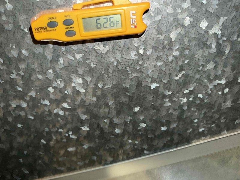 Completed spring cooling tune-up on residential air conditioning system. Performed comprehensive inspection of condenser unit, verified thermostat operation showing 74°F set point in hold mode, and documented severe frost accumulation on evaporator coil with surface temperature reading of 62.6°F. The extensive ice buildup on the coil indicates potential airflow restriction, refrigerant charge issue, or system operating continuously below design parameters that will require further diagnosis and correction to restore proper cooling performance.