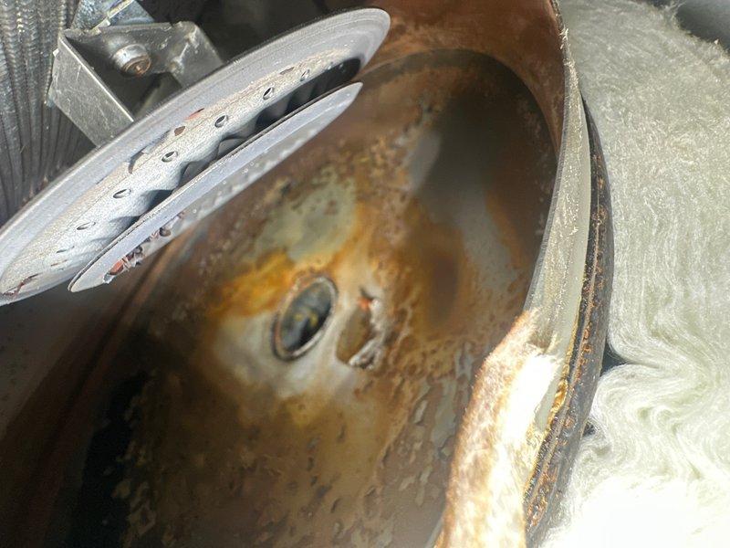 Responded to service call for water heater not functioning following flooding event. Upon arrival, found water heater with open access panel and visible internal components exposed. Inspection revealed significant water damage to unit and surrounding mechanical systems. Blower assembly exhibited extensive rust and corrosion throughout, indicating prolonged moisture exposure with heavy oxidation on interior surfaces and metal components. Assessed electrical connections and internal wiring for water damage and safety concerns. Documented equipment condition with photos showing corroded blower wheel, compromised internal components, and flood-related damage to mechanical systems. Provided customer with findings and recommendations for necessary repairs or replacement.