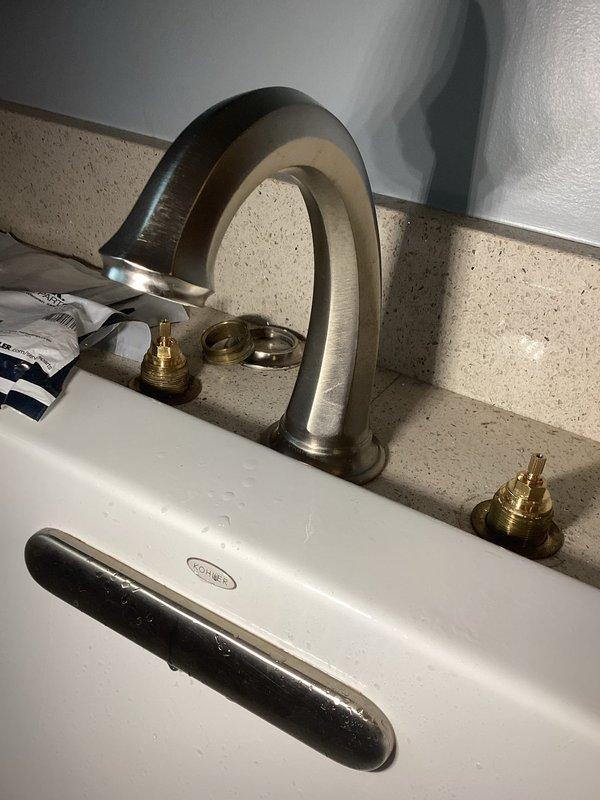 Responded to service call for master bathroom sink with inoperative shut-off valves preventing localized water control. Inspected widespread faucet installation with brushed nickel finish and identified faulty supply line valves requiring customer to use main water shut-off for the entire residence. Documented existing three-piece faucet configuration with separate handles and curved spout mounted on granite countertop. Assessed valve accessibility and photographed installation for repair recommendations.