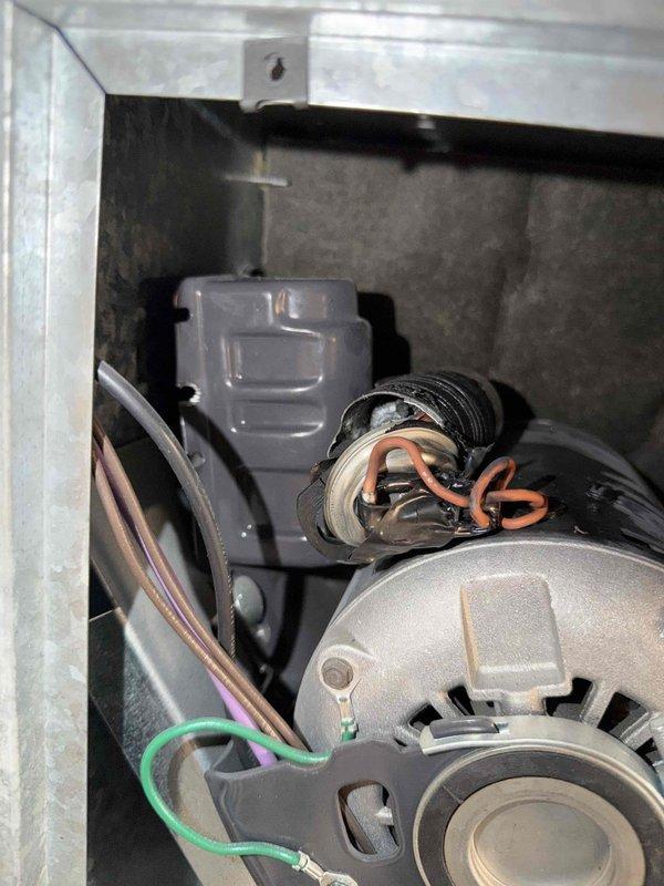 Responded to no-cooling call with reported chemical odor emanating from Unico high-velocity air conditioning system in basement. Upon inspection, accessed blower compartment and air handler unit to investigate odor source and system malfunction. Performed visual inspection of blower motor assembly, electrical connections, and evaporator coil section. Identified potential refrigerant leak or electrical component failure as source of chemical smell. Documented system condition with interior compartment showing blower motor, wiring connections including ground wire routing, and control components. Inspected attic-mounted air handler with open access panels revealing blower assembly and copper refrigerant lines. Examined ductwork connections, insulated refrigerant piping, and shutoff valves for proper operation and leak indicators.