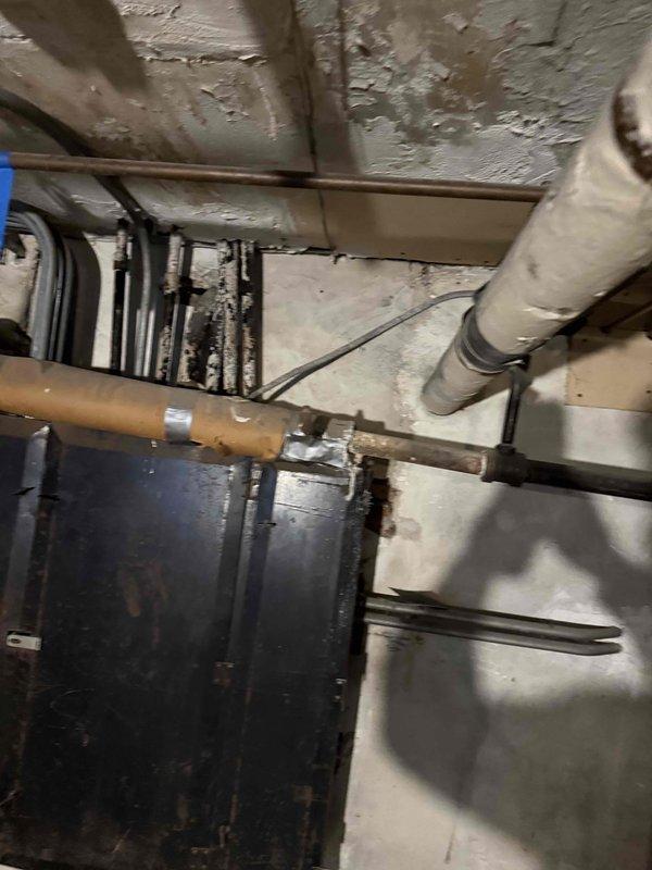 Conducted on-site evaluation of vintage first-floor condo unit to assess requirements for new cooling system installation. Inspected existing basement mechanical space, documenting current HVAC infrastructure including exposed ductwork, copper refrigerant lines, PVC condensate drainage, and electrical service panel accessibility. Evaluated ceiling joist configuration, available clearances for equipment placement, and existing utility connections to determine optimal system sizing and installation approach for split-system air conditioning unit.