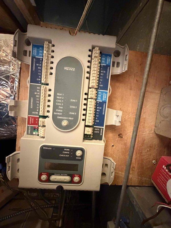 Disconnected existing Honeywell HZ322 multi-zone HVAC control system and converted system to single-zone operation. Cut drywall to access zone dampers throughout ductwork and manually locked all dampers in the open position to allow unrestricted airflow. Removed zone control wiring from terminal blocks and bypassed zoning panel to restore direct thermostat control to HVAC unit. System tested and confirmed operational as single-zone configuration with proper airflow to all areas.