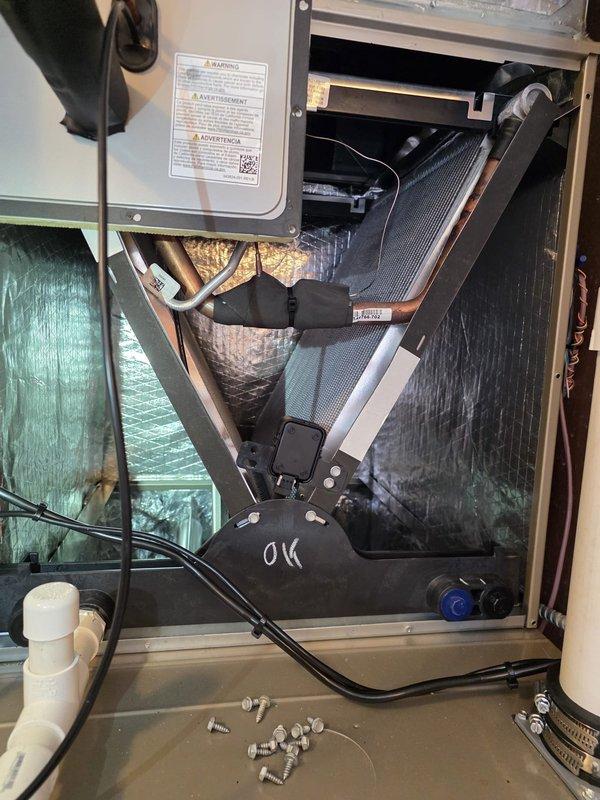 Responded to warranty call for evaporator coil noise complaint. Accessed air handler unit and inspected internal components including evaporator coil assembly, refrigerant lines, blower compartment, and electrical connections. Examined copper refrigerant tubing with insulation, flexible ductwork connections, and heat exchanger assembly for signs of loose mounting hardware, debris contact, or mechanical interference. Verified all mounting brackets and fasteners were properly secured. Inspected outdoor refrigerant line set connections and insulation integrity. All components found to be properly installed and secured with no visible defects or interference points that would cause operational noise. System marked as operational and meeting manufacturer specifications.
