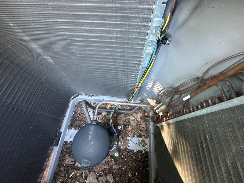 Returned to property to complete installation of furnace switch in first-floor unit as scheduled. Upon arrival, accessed outdoor condensing unit and documented existing conditions prior to service work. Unit showed significant accumulation of organic debris including leaves, dirt, and decomposed plant matter in bottom pan and around compressor base. Debris had collected around electrical junction box and between condenser coil fins, restricting airflow and creating potential operational concerns.

Completed switch installation in furnace as planned. Verified electrical connections and proper switch operation. Cleaned accumulated debris from condensing unit housing, electrical box area, and condenser coil fins to restore proper airflow and prevent future electrical issues. Inspected refrigerant lines, compressor mounting, and electrical wiring for any weather-related damage or deterioration. All components functioning within normal parameters following installation and cleaning procedur