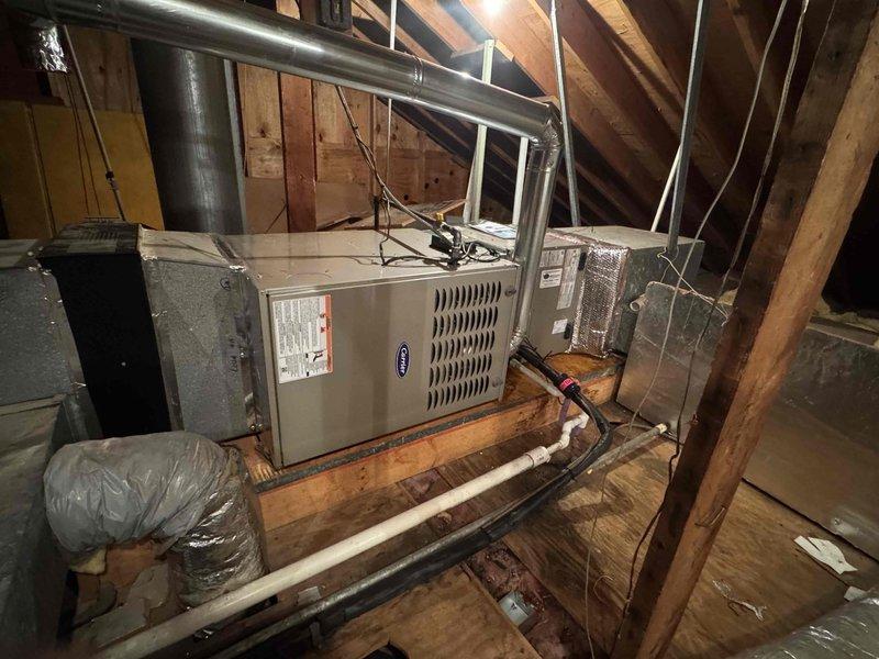 Completed horizontal furnace installation in attic space for second-floor heating zone. Installed Carrier HVAC unit on wooden joists with proper clearances, connected supply and return ductwork with insulated flex connections, and ran necessary electrical and control wiring. Installed T6 programmable thermostat and verified system operation with digital diagnostics showing proper temperature differentials of 33.7°F and 35.0°F across the system components.