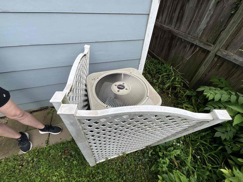 Conducted comprehensive evaluation of 24-year-old Carrier R22 air conditioning system with intermittently failing condenser fan motor. Assessed outdoor condenser unit housed in wooden lattice enclosure and inspected indoor ductwork and plenum assembly in basement mechanical space. Provided detailed replacement estimate for complete AC system upgrade due to obsolete R22 refrigerant phase-out and deteriorating condenser fan motor requiring full system replacement rather than repair of aging equipment.