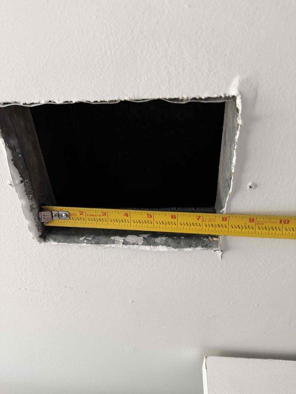Responded to no cooling call on aging air conditioning system. Upon inspection, accessed ductwork through wall opening to diagnose airflow restrictions and verify proper system operation. Measured and documented access point dimensions for potential future service requirements.