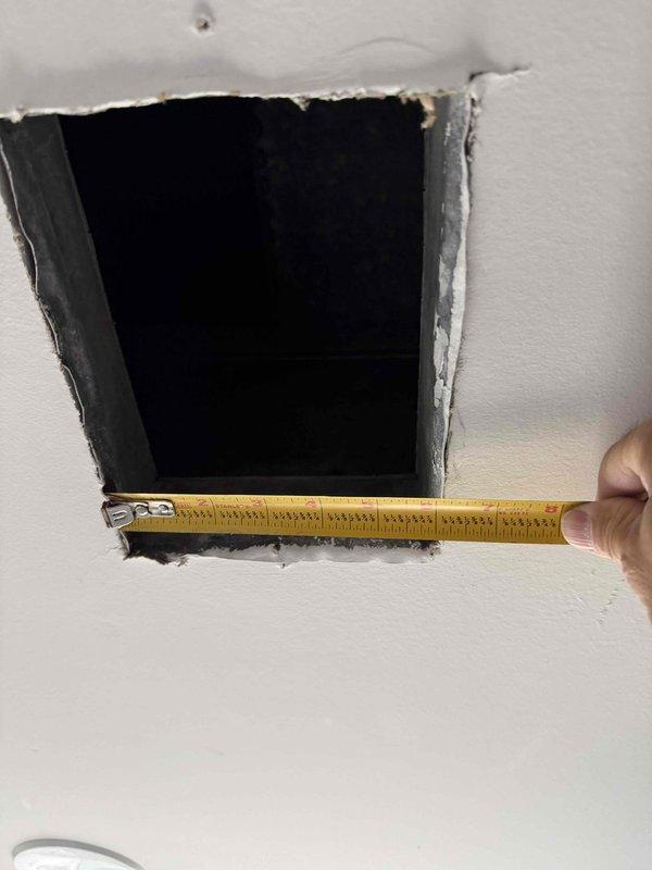 Responded to no cooling call on aging air conditioning system. Upon inspection, accessed ductwork through wall opening to diagnose airflow restrictions and verify proper system operation. Measured and documented access point dimensions for potential future service requirements.
