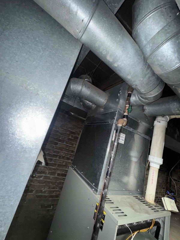 Completed scheduled maintenance agreement service on central air conditioning system over 10 years old with convenient basement access. Performed comprehensive inspection of furnace unit, blower motor assembly, ductwork connections, and refrigerant lines. Documented existing rust staining on blower platform and general dust accumulation typical of system age, with all components currently operational and accessible for future service needs.
