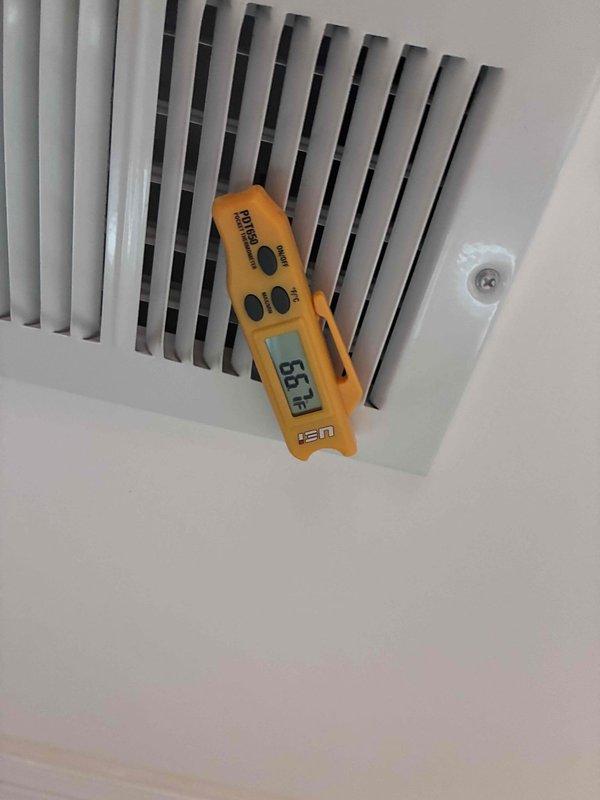 Responded to no airflow complaint on 10+ year old air conditioning system. Upon arrival, confirmed outdoor compressor was running but indoor unit was not delivering conditioned air to living space. Measured supply air temperature at register showing 65.4°F, indicating inadequate cooling performance. Inspected attic installation and identified failed or disconnected supply duct at plenum connection. Flexible ductwork was found completely detached from main trunk line, causing all conditioned air to dump into attic space rather than reaching occupied areas. Reconnected supply duct to plenum and secured connection properly. Verified airflow restoration at registers and system operation returned to normal. Customer declined further repairs at this time.