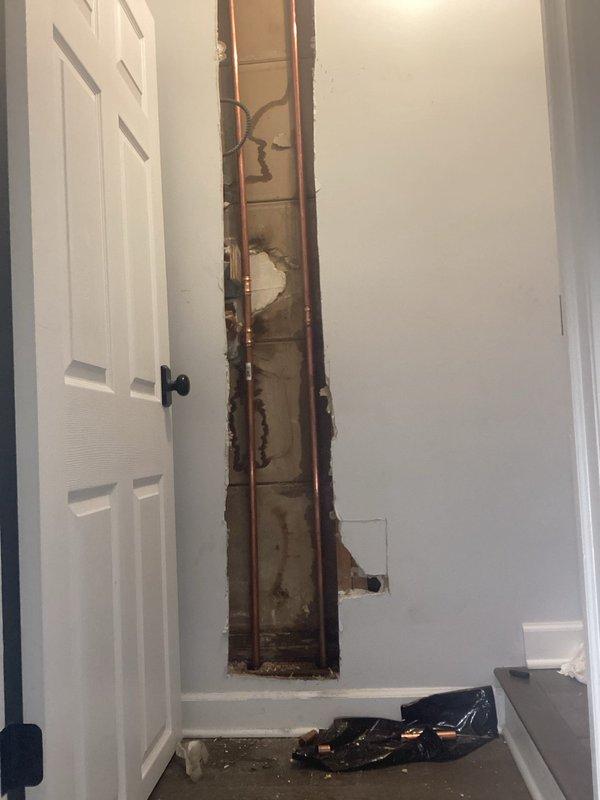 Replaced leaking galvanized pipe riser with new copper piping. Removed section of interior drywall to access vertical plumbing lines, cut out deteriorated galvanized pipe, and installed copper pipe with brass fittings to restore proper water flow and eliminate leaks.