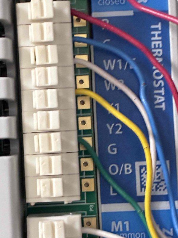 Return visit to system after allowing evaporator coil to thaw from previous frozen condition. Inspected Honeywell zoning control panel showing zones 1 and 2 active, verified thermostat wiring connections at control board including common, heat, cool, and fan circuits. System ready for further diagnostics once coil completely thawed.