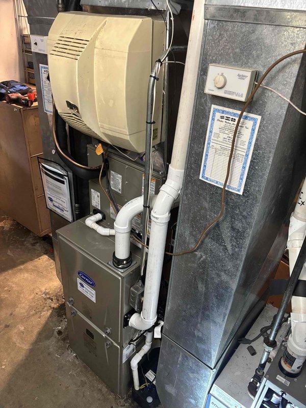 Completed full HVAC system replacement including furnace, condenser, and evaporator coil for primary system, plus additional condenser and coil replacement for secondary system. Installed new gray furnace unit in basement with integrated whole-house humidifier mounted on supply plenum. Configured white PVC condensate drainage and venting systems per manufacturer specifications. Ran refrigerant lines and completed all electrical connections for both systems. All equipment tested and verified operational upon completion.