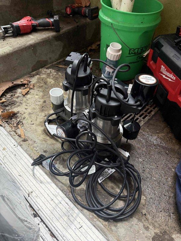 Returned to property to complete installation of new sump pump, ejector pump, and battery backup system in basement utility area. Removed existing failed pumps from concrete sump pit and ejector basin, which showed significant age-related deterioration and water staining. Installed replacement submersible pumps with appropriate discharge piping connections using PVC fittings and brass components. Configured battery backup system to ensure continued operation during power outages. Tested all pump operations, float switches, and discharge flow to verify proper functionality. System is now operational and providing reliable water removal and sewage ejection capabilities.