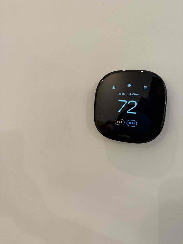 Conducted comprehensive site survey of commercial facility to document all HVAC equipment and components. Identified and photographed all units, recorded model and serial numbers, documented filter sizes, and cataloged thermostat locations and types throughout the space. Survey included exposed ductwork system in industrial-style ceiling area and digital thermostat set at 72 degrees with programmable features.