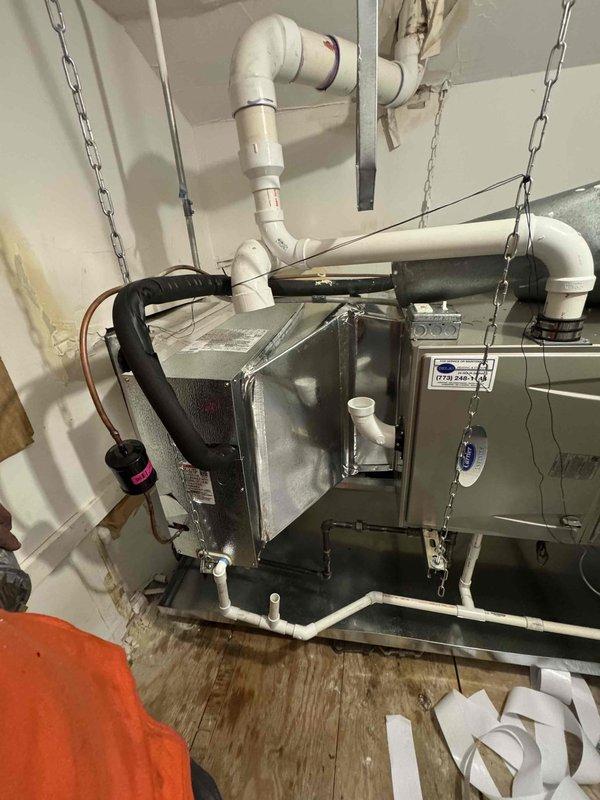 # HVAC Install - A/C Only

Completed full air conditioning system replacement including outdoor condenser unit and indoor evaporator coil. Removed existing equipment and installed new condenser on exterior pad against brick foundation wall with proper clearances maintained from structure and landscaping. Unit positioned to optimize airflow and service access while minimizing visual impact on property aesthetics.

Installed new evaporator coil in basement mechanical space, properly suspended and secured to structural supports. Established refrigerant line connections between indoor and outdoor components using appropriate copper piping with proper insulation. Connected condensate drainage system utilizing PVC piping with multiple drain points and proper pitch to prevent water backup. Verified all electrical connections meet code requirements and manufacturer specifications.

System was evacuated, leak tested, and charged with refrigerant to manufacturer specifications. Performed operati