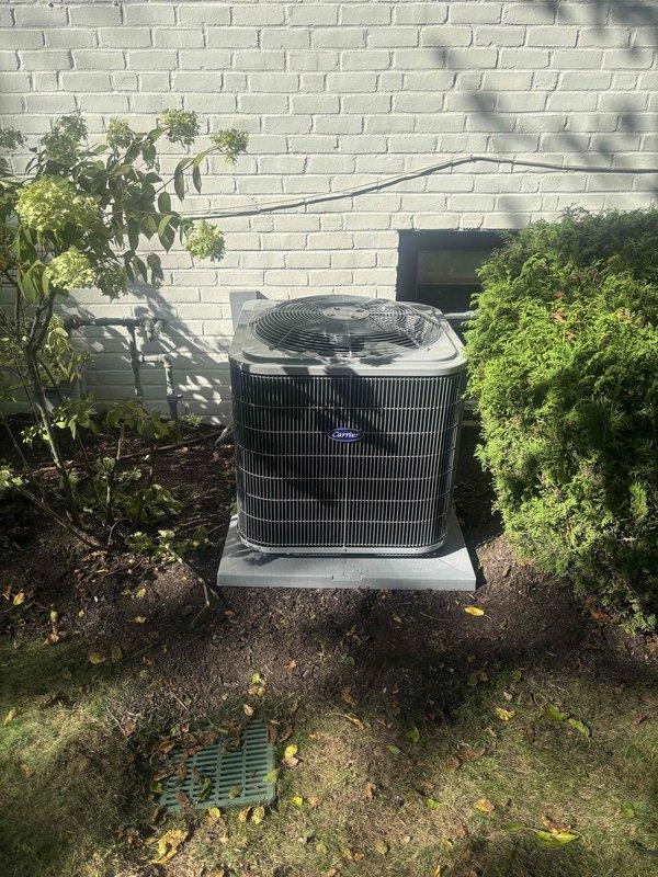Completed full HVAC system replacement including outdoor Carrier condenser unit, Unico air handler with evaporator coil, and thermostat. The condenser was installed on existing concrete pad against exterior brick wall with proper refrigerant line routing and electrical connections. Interior air handler and coil were installed in conditioned space with appropriate insulation and vapor barrier placement. All refrigerant lines were properly insulated, system was evacuated, charged to manufacturer specifications, and tested for proper operation. New thermostat was installed and programmed for optimal system performance. Three-technician crew completed installation in one day with all components functioning within normal operating parameters.