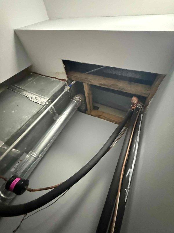 Responded to no cooling complaint on residential HVAC system less than 10 years old. Upon arrival, inspected furnace and air conditioning unit located in interior utility closet with connected refrigerant lines and ductwork. Verified system installation and checked saturation temperatures as directed for diagnostic assessment. Documented equipment condition and mechanical room configuration with photos showing gas line connections, refrigerant line routing through ceiling access, and overall system layout. Coordinated with technical support regarding temperature readings and diagnostic findings. Payment approved for diagnostic service and any necessary repairs via ACH processing per customer authorization.