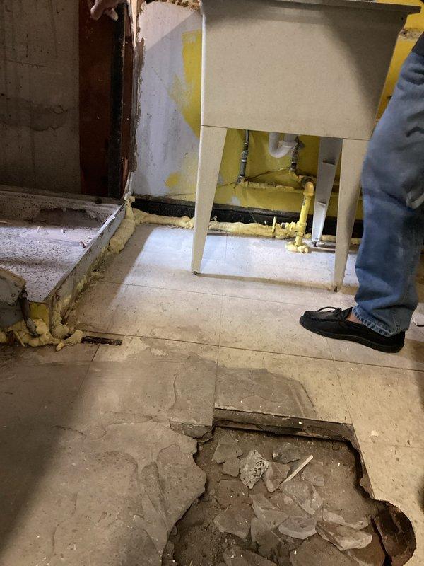 Completed inspection and estimate for bathroom vanity replacement in active renovation area with significant floor damage and exposed plumbing infrastructure. Assessment confirmed need for licensed plumber to properly disconnect existing supply lines, remove current fixtures, install new vanity cabinet, and reconnect water supply and drain assembly including P-trap configuration. Documented extensive tile damage, exposed substrate, yellow foam insulation application, and partially installed cabinetry requiring professional plumbing connections to meet code requirements.