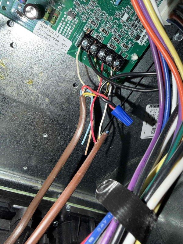 Returned to complete installation of EZ Trap condensate drain assembly using oscillating tool to modify existing drain line configuration. Successfully integrated new trap fitting with red coupling connector into PVC drain system between floor joists, ensuring proper condensate drainage and air seal. Verified all electrical connections at control board terminal block remained secure and system operational upon completion.