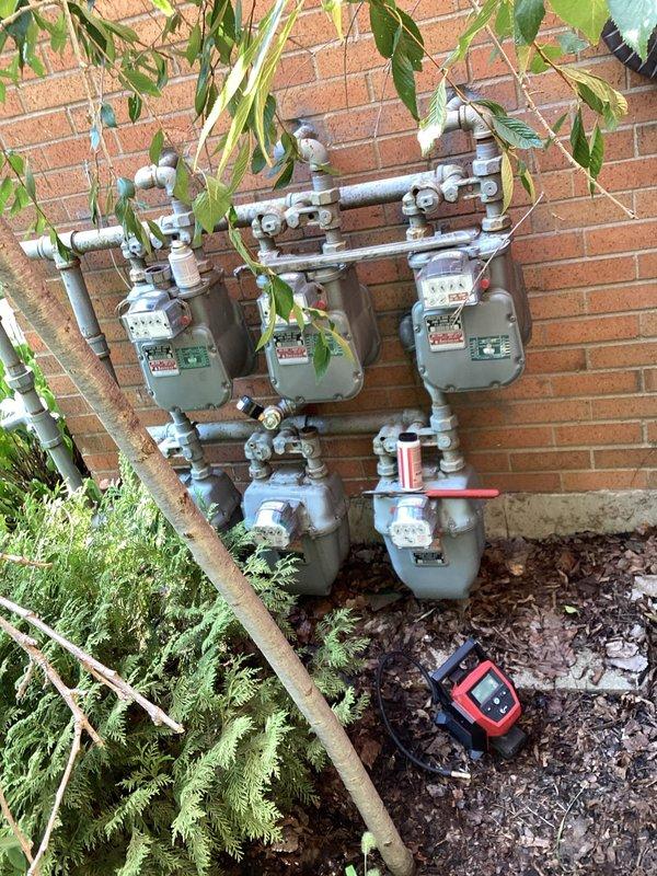 Performed comprehensive gas pressure test on multi-meter natural gas system serving the property. Main gas supply remains shut off pending resolution of system integrity concerns. Testing conducted on manifold configuration serving five individual gas meters mounted on exterior wall, utilizing calibrated pressure gauge to verify system holds proper pressure specifications and identifying any potential leaks or pressure drops that would prevent safe restoration of gas service.