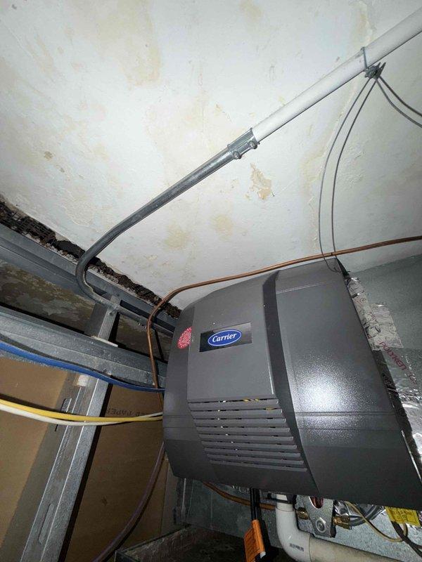 Responded to service call for power humidifier replacement at residential property. Upon arrival, accessed existing humidifier unit mounted within HVAC system. Removed old humidifier assembly showing signs of age and discoloration on fan blades and internal components. Installed new power humidifier unit, ensuring proper electrical connections and integration with existing Carrier furnace system. Verified operational functionality of new humidifier, confirmed adequate airflow through fan assembly, and tested system controls. Completed installation with all components properly secured and system restored to full operation.