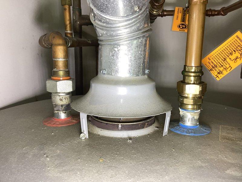 Responded to no hot water complaint and performed diagnostic evaluation of tanked water heater system. Upon inspection, identified standard residential gas water heater installation with copper supply lines, brass shut-off valves with red and white handle indicators, and proper drain pan configuration. Verified all plumbing connections at inlet and outlet ports, including compression fittings and brass coupling nuts. Examined water heater for proper venting through metallic ductwork and confirmed unit specifications via manufacturer labels and energy guide information. Assessed condition of copper piping showing normal patina oxidation consistent with system age. Documented complete installation including safety valves, temperature and pressure relief components, and gas supply connections. Coordinated access with tenant for appointment window and completed thorough visual inspection of water heater closet including adjacent HVAC equipment. Photographed installation details for service