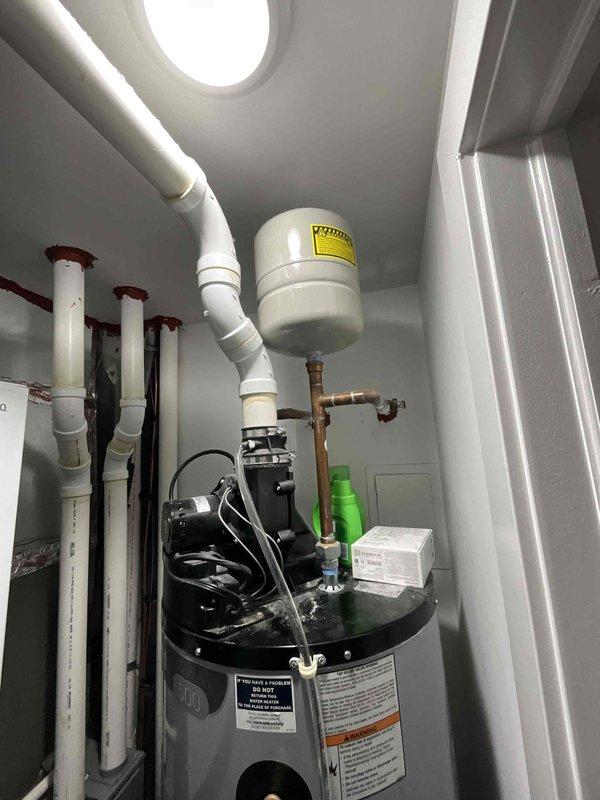 Completed replacement of existing tank-style water heater with new Navien tankless unit in utility closet. Previous tank configuration restricted access to HVAC equipment located behind the water heater, requiring equipment upgrade to resolve accessibility issues for future maintenance and service requirements.