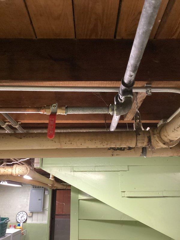 Responded to no water delivery issue affecting boiler system from main water supply line. Diagnosed water supply interruption at main feed line to boiler, identified closed or malfunctioning valve preventing water flow to heating system. Restored water supply by opening shut-off valve with red handle visible on main supply line, verified proper water delivery to boiler system and confirmed restoration of normal operating pressure.