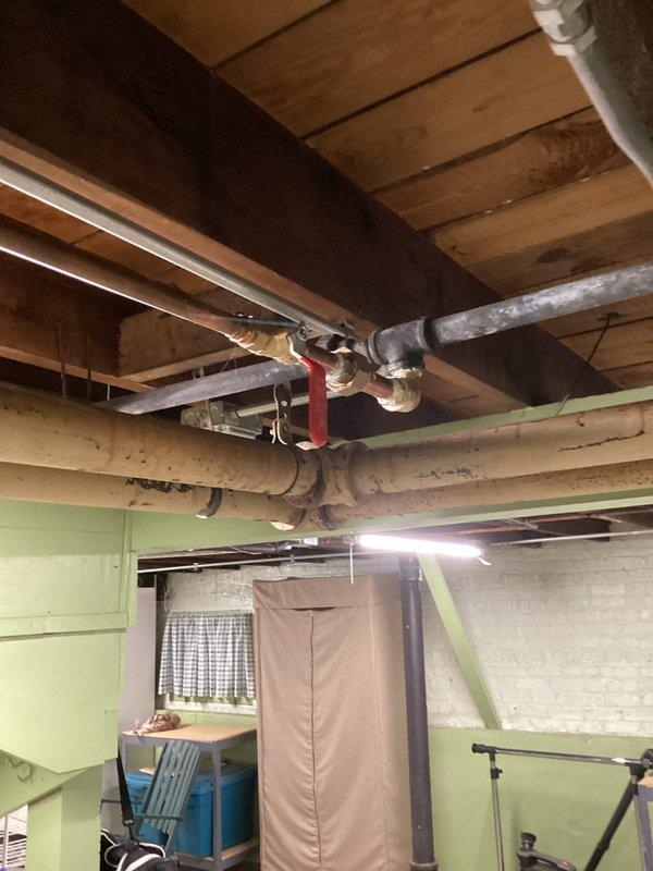 Responded to no water delivery issue affecting boiler system from main water supply line. Diagnosed water supply interruption at main feed line to boiler, identified closed or malfunctioning valve preventing water flow to heating system. Restored water supply by opening shut-off valve with red handle visible on main supply line, verified proper water delivery to boiler system and confirmed restoration of normal operating pressure.