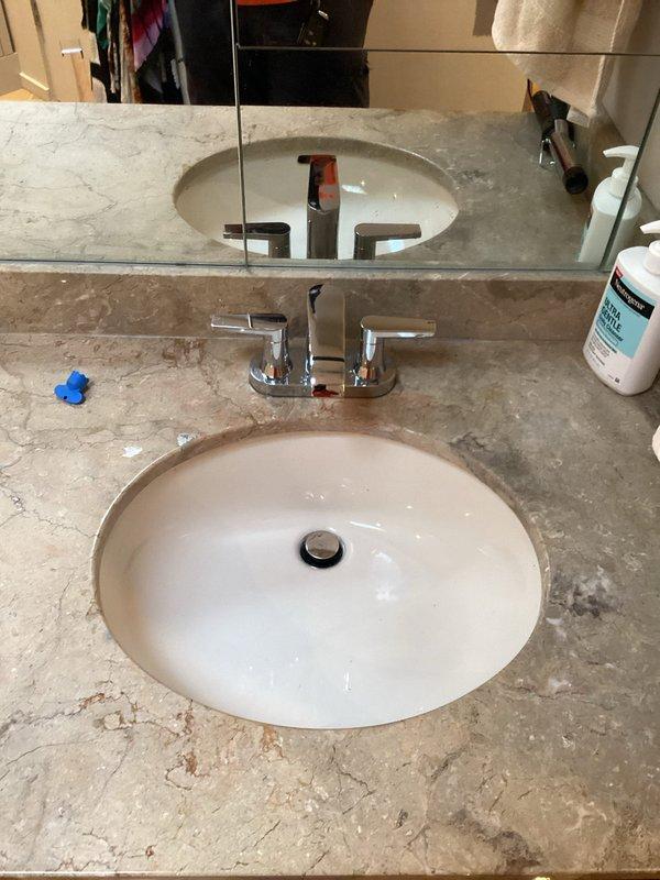 Successfully installed two new Kallista lavatory faucets (Model# P32445LV) with chrome finish and cross-handle controls on dual bathroom vanities with undermount sinks. Both faucets were mounted on beige speckled stone countertops, with supply lines connected and tested for proper operation. Assessed site conditions for upcoming sink installation work and evaluated outdoor faucet setup for future service needs.
